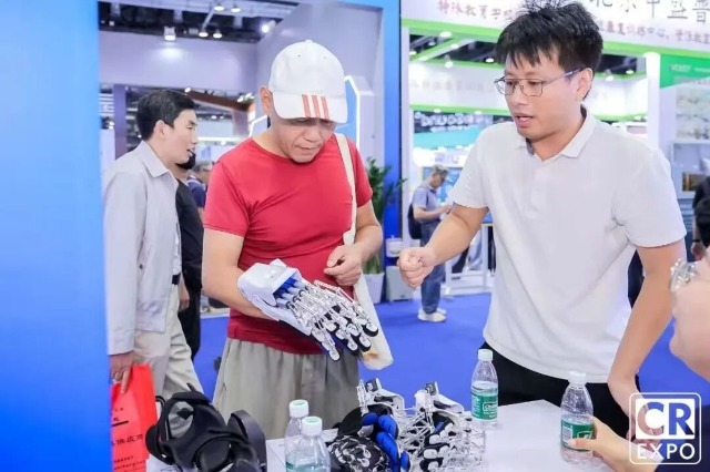 于金须在博览会上向来宾介绍手部康复机器人 学校供图.jpg 于金须在博览会上向来宾介绍手部康复机器人 学校供图.jpg